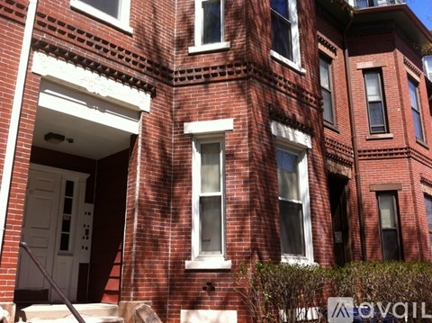 A red brick building with a white door and windows.