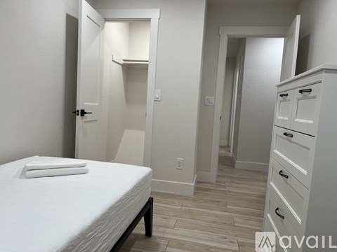A bedroom with a bed, dresser, and closet.