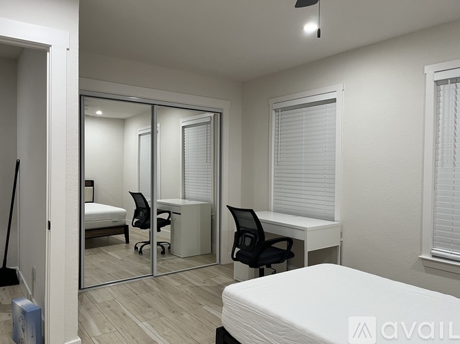 A bedroom with a bed, desk, and chair.