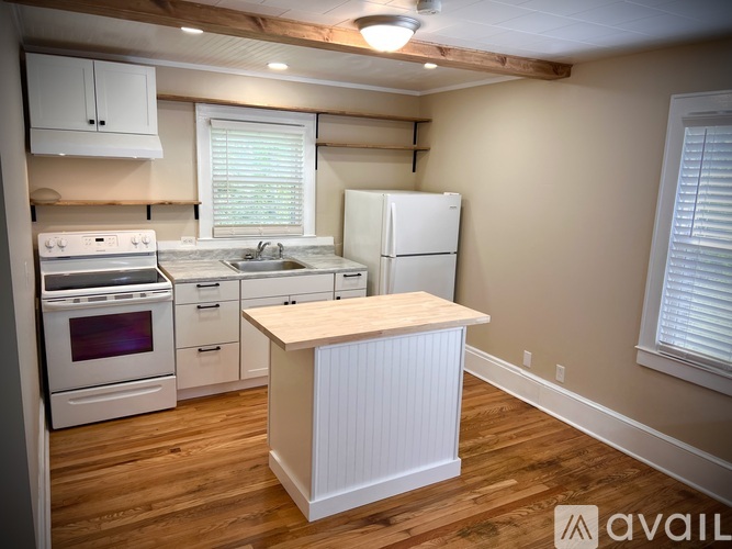 A kitchen with wooden floors and white appliances.