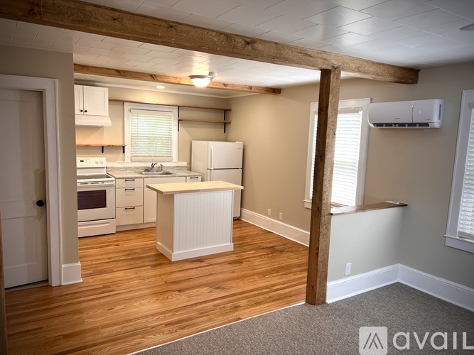 A kitchen with wooden floors and white appliances.