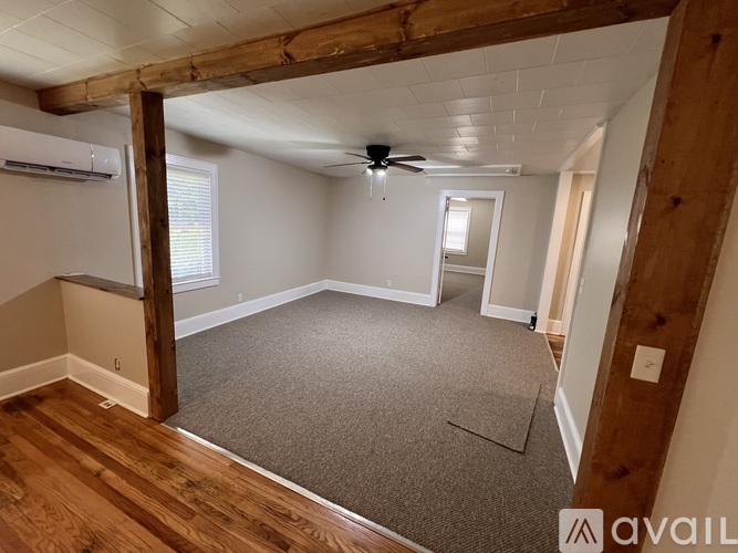 A room with a carpeted floor and a ceiling fan.