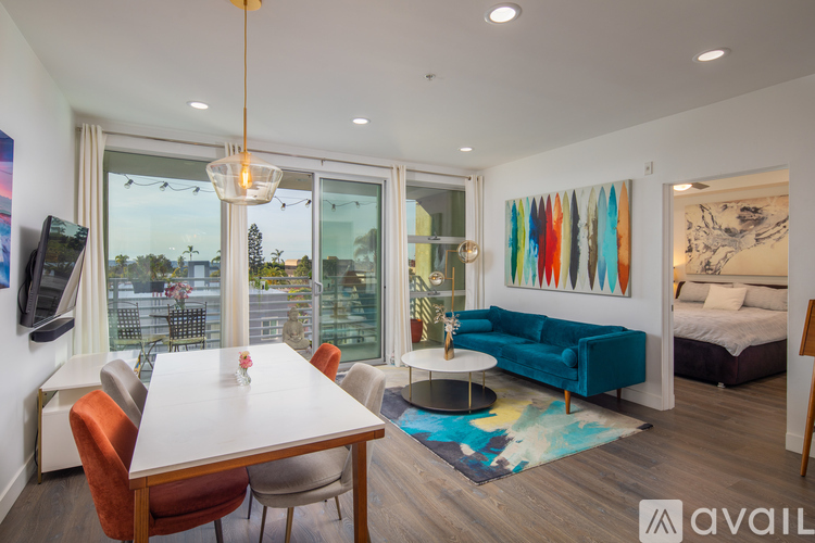 A modern living room with a white dining table and orange chairs.