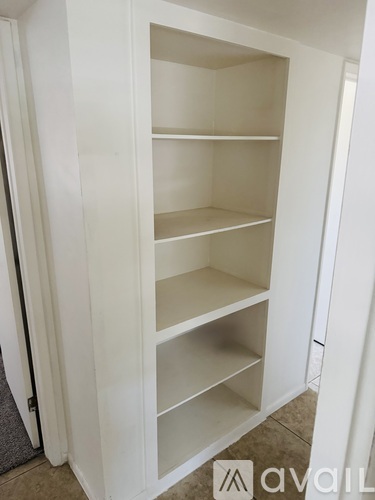 A white cabinet with multiple shelves is open.