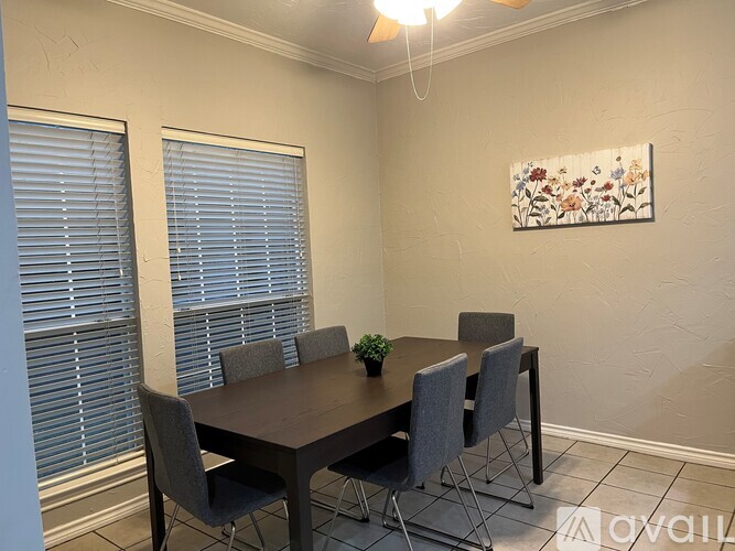 A dining room with a table and chairs.