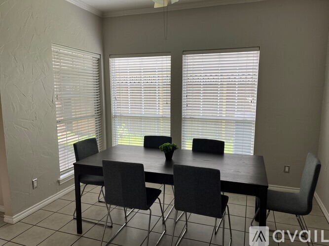 A dining room with a table and chairs.