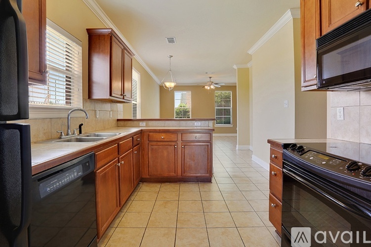 A kitchen with wooden cabinets and black appliances.