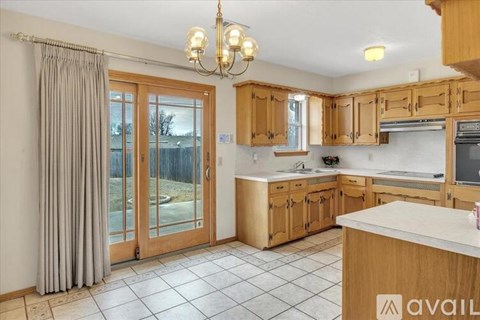 A kitchen with wooden cabinets and a large island.