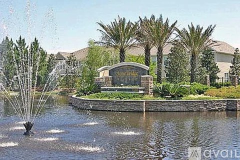 A fountain in the middle of a lake with a sign that says "Avalon".