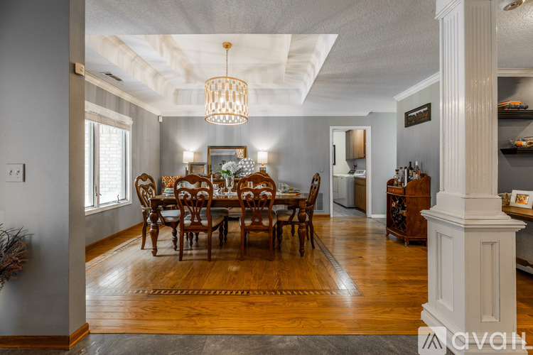 A dining room with a wooden table and chairs.