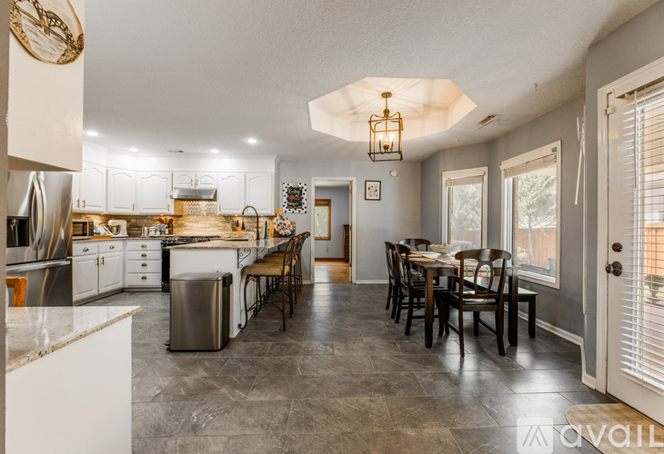 A kitchen with a table and chairs in the middle of the room.