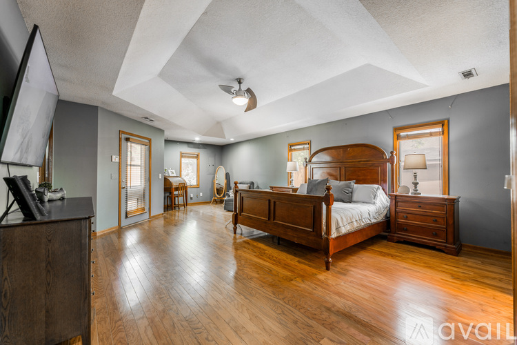 A bedroom with a large bed and wooden floors.