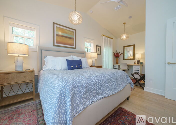 A bedroom with a large bed and a painting on the wall.