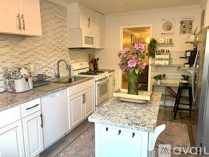 A kitchen with white cabinets and granite countertops.