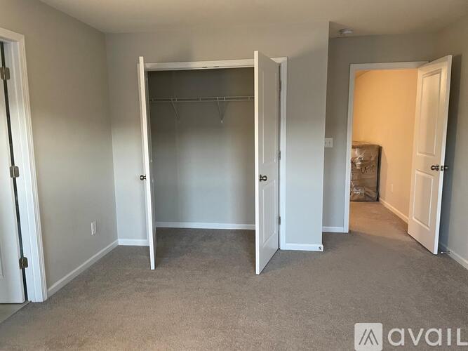 A room with a carpeted floor and a white closet with a door open.