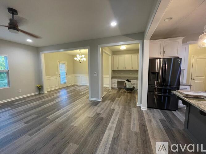 A spacious kitchen with a refrigerator, cabinets, and a dining area with a table and chairs.