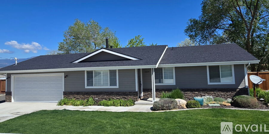 A house with a grey roof and a white garage door.