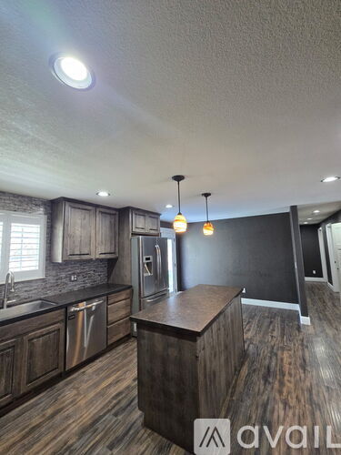 A kitchen with wooden cabinets and a blackboard on the wall.
