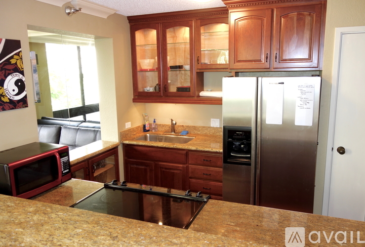 A kitchen with a refrigerator, microwave, and oven.