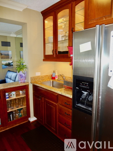 A kitchen with a refrigerator and a sink.