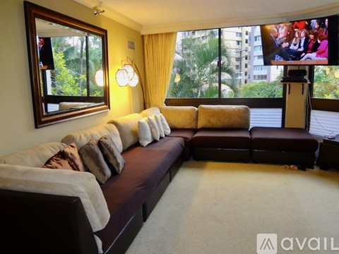 A living room with a large couch and a television on a stand.