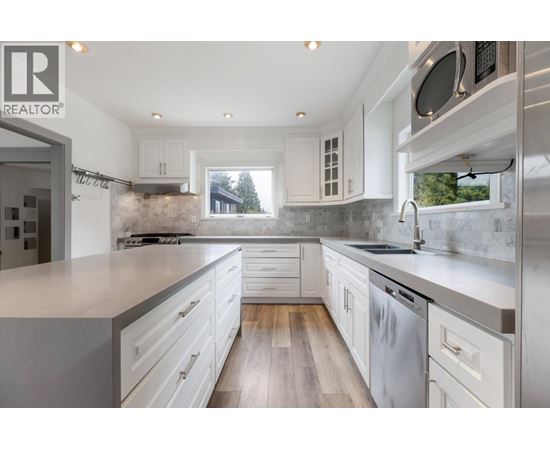 A modern kitchen with white cabinets and a large island.