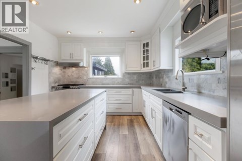 A modern kitchen with white cabinets and a large island.