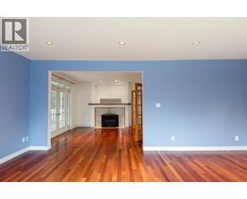 A spacious room with a fireplace and wooden floors.