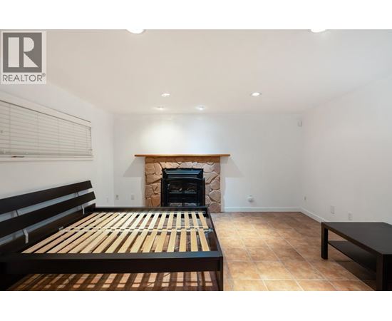 A bedroom with a fireplace and a bed.