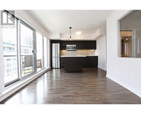 A modern kitchen with dark wood floors and white walls.