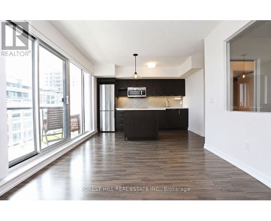 A modern kitchen with dark wood floors and white walls.