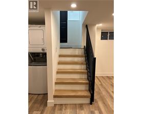 A staircase with wooden steps and a black railing.