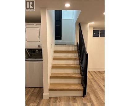 A staircase with wooden steps and a black railing.
