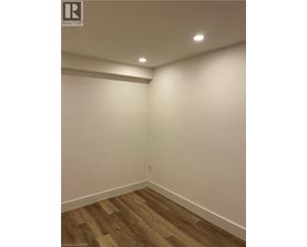 A room with wooden flooring and white walls.