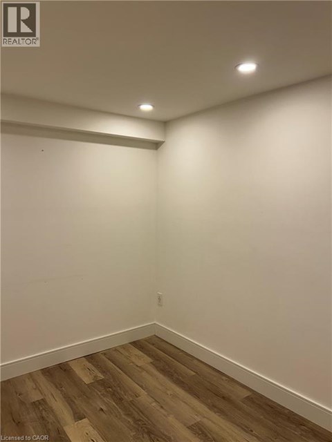 A room with wooden flooring and white walls.