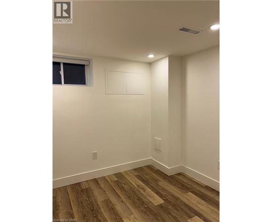 A room with wood flooring and white walls.
