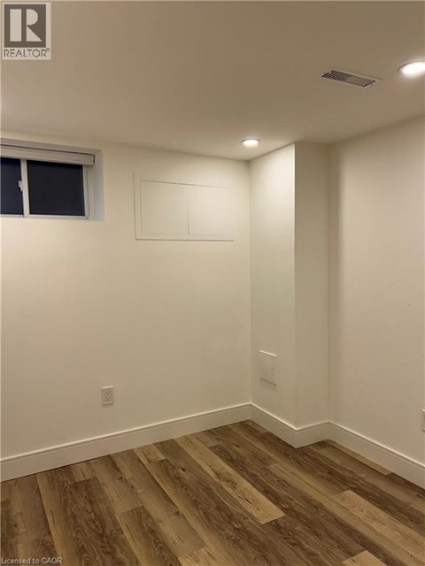 A room with wood flooring and white walls.