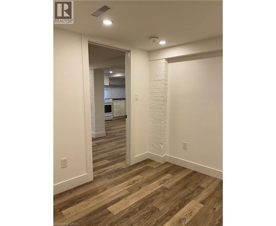 A hallway with wood flooring and white walls.