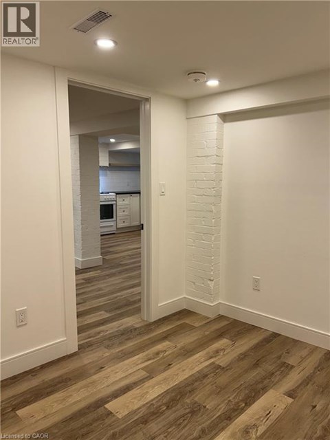 A hallway with wood flooring and white walls.
