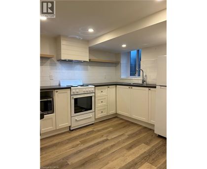 A kitchen with white cabinets and a black countertop.