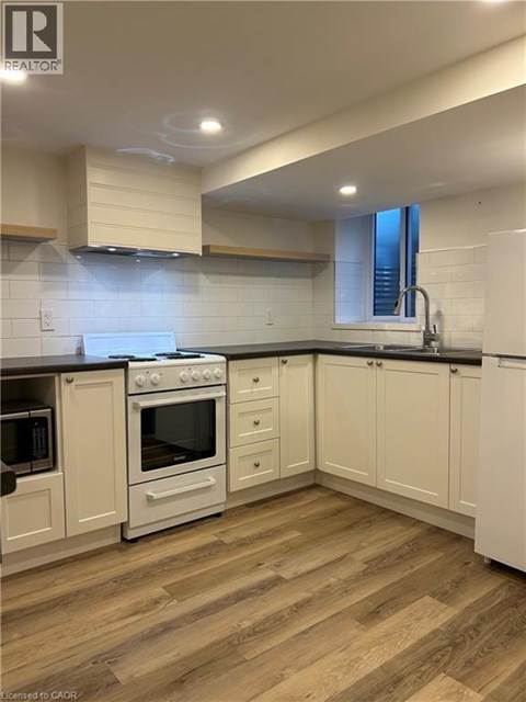 A kitchen with white cabinets and a black countertop.