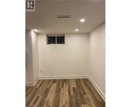 A room with wooden flooring and a window.