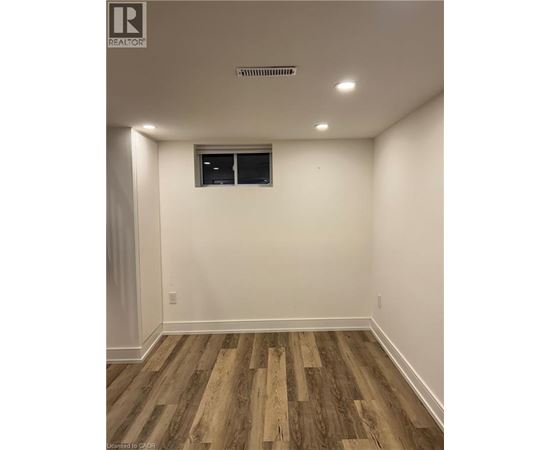 A room with wooden flooring and a window.