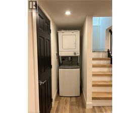 A white dishwasher is in a narrow hallway.