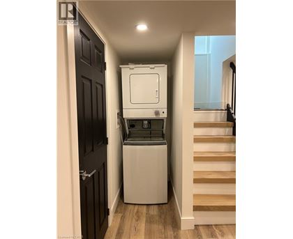 A white dishwasher is in a narrow hallway.