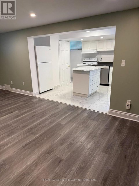 A kitchen with white appliances and a white refrigerator is shown.