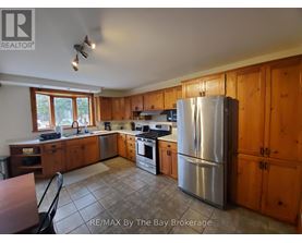 A kitchen with wooden cabinets and a stainless steel refrigerator.