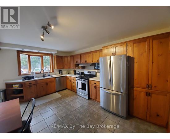 A kitchen with wooden cabinets and a stainless steel refrigerator.