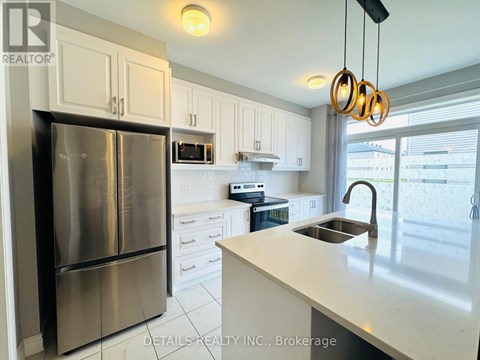 A kitchen with a stainless steel refrigerator and white cabinets.