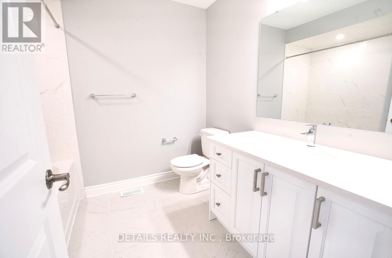 A white bathroom with a toilet, sink, and mirror.